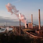 Blick auf den Rhein und die Kokerei Schwelgern mit Wasserdampf und Werksbeleuchtung.
