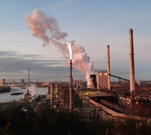 Blick auf den Rhein und die Kokerei Schwelgern mit Wasserdampf und Werksbeleuchtung.